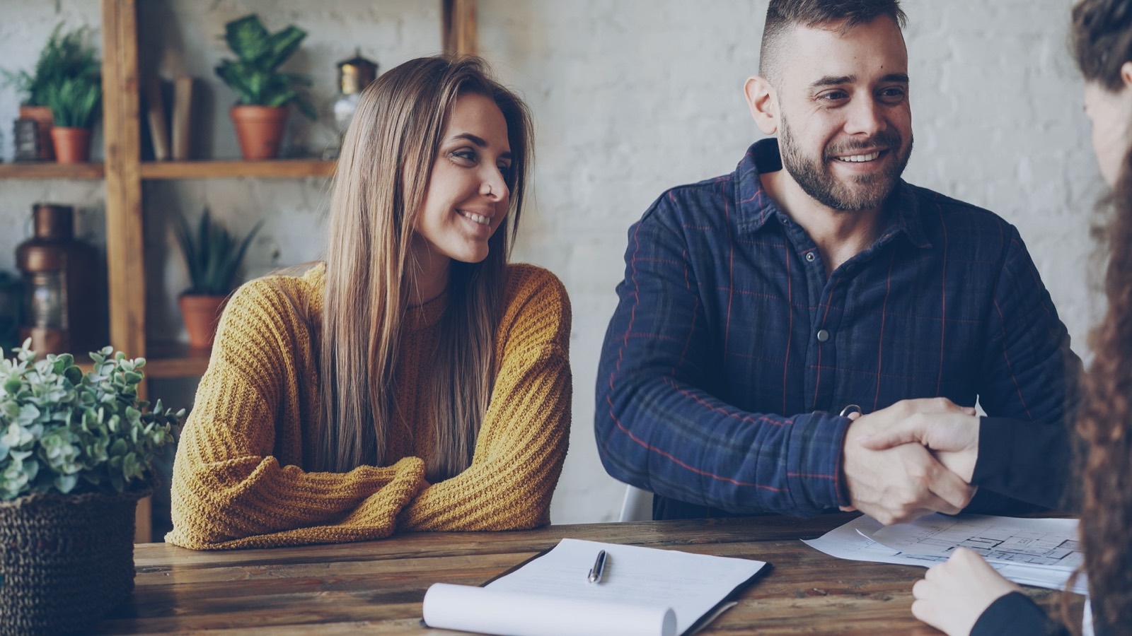 Two customers talking across a table with drawings in front of them